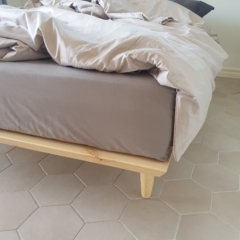 Close-up corner view of the raw pine Air Bed 160x200 cm frame, illustrating the joinery detail of the frame and the profile of one of the angled support legs.