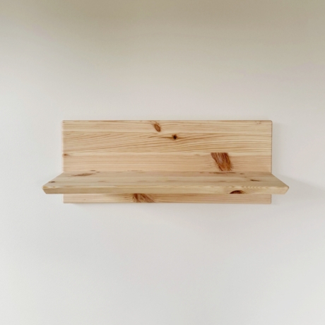 Ein 50 cm breites Rohe Air Wandregal aus natürlichem Kiefernholz, an einer weißen Wand montiert. Das Regal verfügt über ein zweiteiliges Design mit einer horizontalen Rückwand und einer kleineren Ablagefläche.