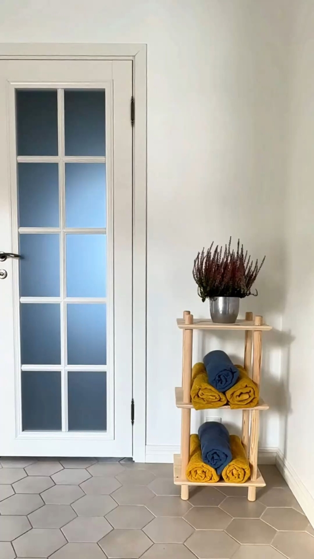 Étagère Air modulaire à trois niveaux, fabriquée en pin brut, démontrant son usage fonctionnel en offrant un accès facile et rapide aux serviettes et aux fournitures essentielles à proximité de la salle de bains ou de la buanderie.