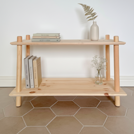 Nahaufnahme des niedrigen, zweistöckigen schmalen modularen Rohe Air Regals aus Kiefernholz. Das Regal ist mit gestapelten Büchern, einer dekorativen Vase und zarten Blumen gestaltet.